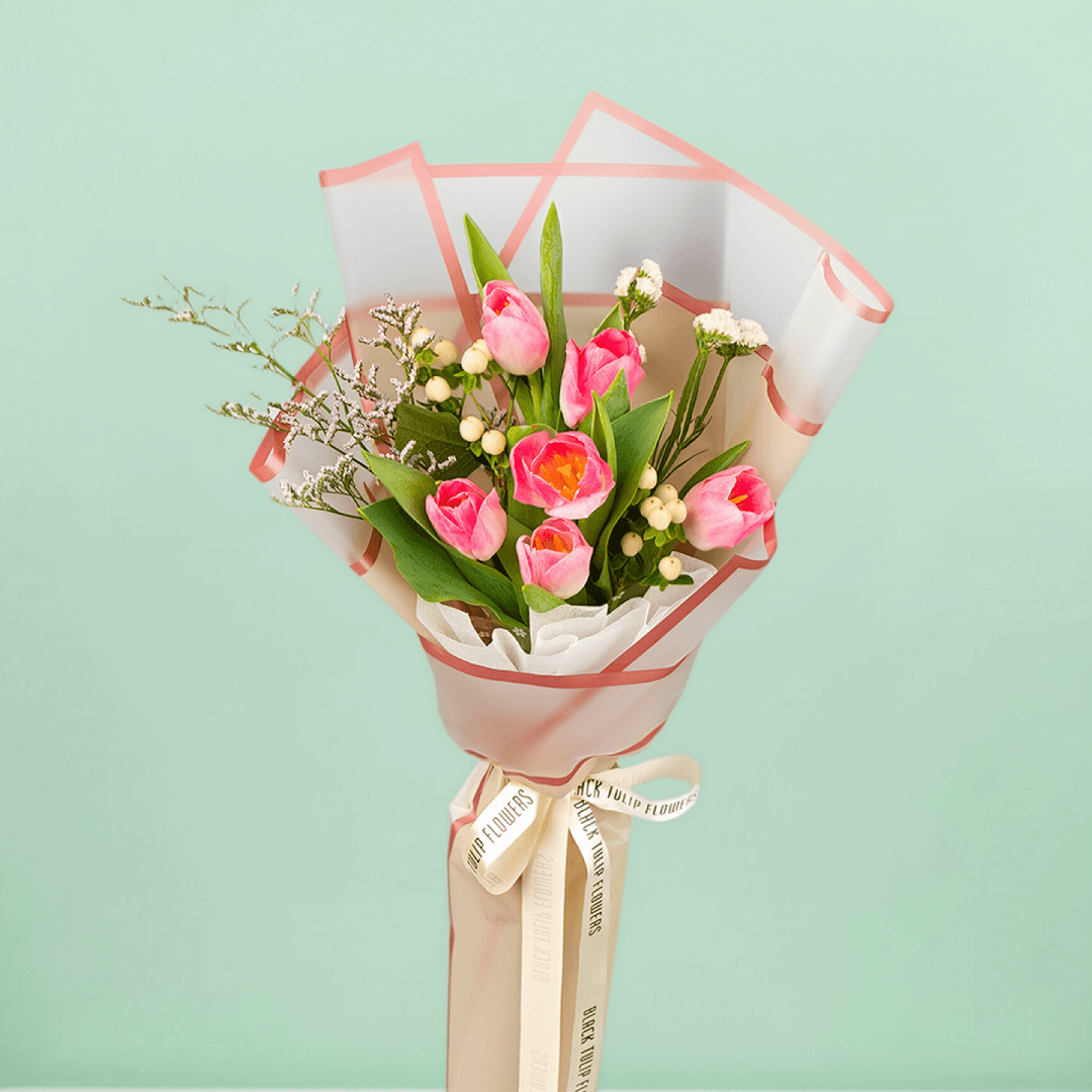Pink tulips with Hypericum and greenery wrapped in Korean-style flower sheets.