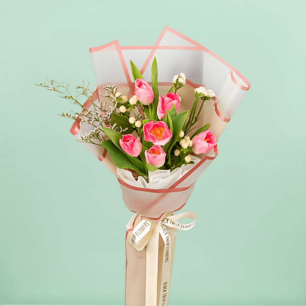 Pink tulips with Hypericum and greenery wrapped in Korean-style flower sheets.