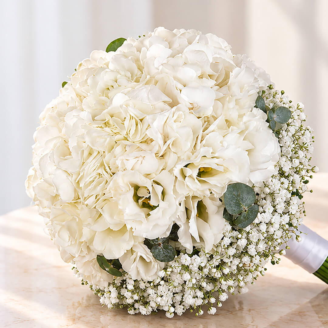 Elegant white hydrangea bridal bouquet featuring eustoma, gypsophila, and eucalyptus in a clean minimalist hand-tied stem wrap.