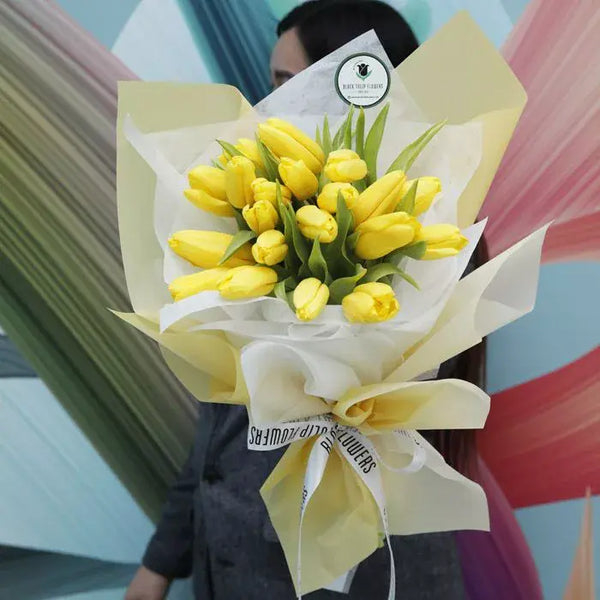 Bouquet of 20 fresh yellow Tulips wrapped in elegant cream non-woven paper.