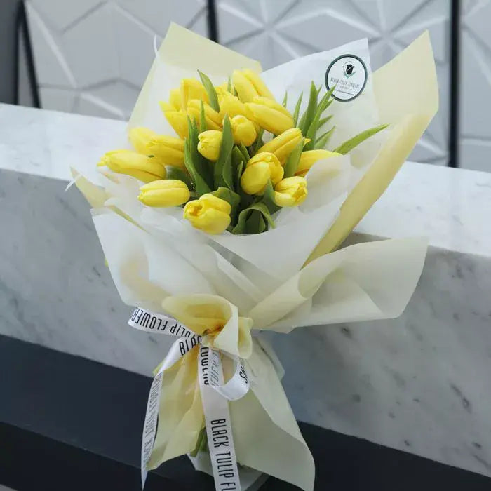 Bouquet of 20 fresh yellow Tulips wrapped in elegant cream non-woven paper.