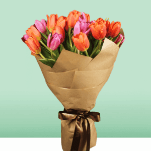 Stunning orange and pink tulips bouquet wrapped in a grey cellophane sheet.