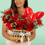 A beautifully arranged rectangle basket featuring 25–30 vibrant red roses, complemented by exotic red Anthurium and delicate Waxflower stems